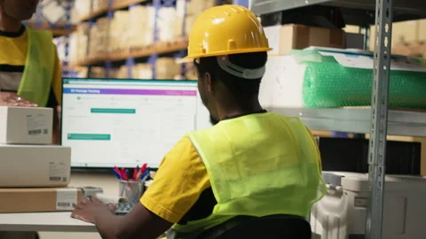 Young man using scanner on barcodes and applying tags in distribution hub Stock Footage 315539033