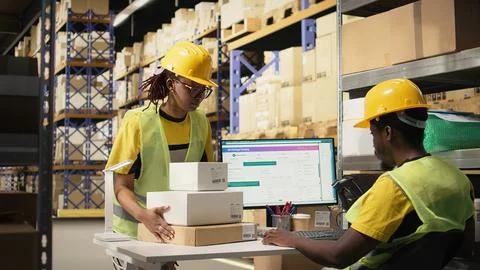 Young man using scanner on barcodes and applying tags in distribution hub Fotos Stock