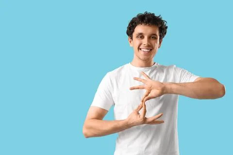 Young man using sign language on blue background Stock Photos