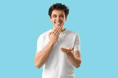 Young man using sign language on blue background Stock Photos