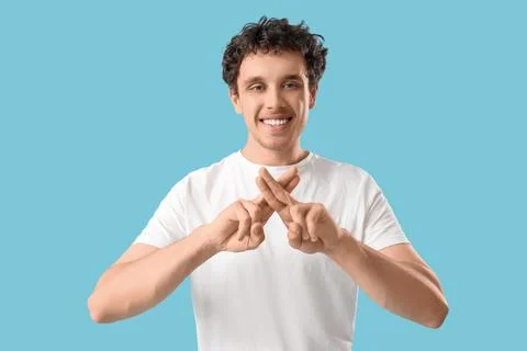 Young man using sign language on blue background Stock Photos