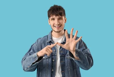 Young man using sign language on blue background Stock Photos