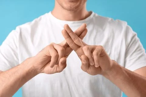 Young man using sign language on blue background, closeup Stock Photos