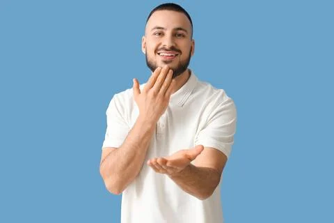 Young man using sign language on blue background Stock Photos