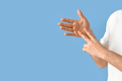 Young man using sign language on blue background, closeup Stock Photos
