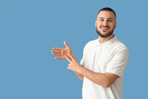 Young man using sign language on blue background Stock Photos
