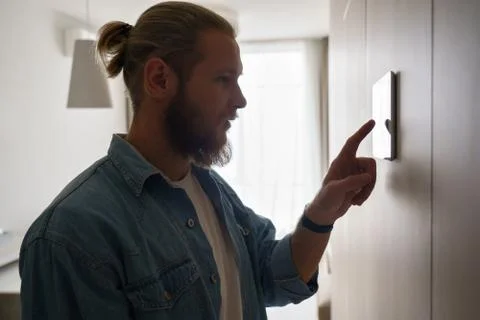 Young man using smart home touch screen technology device on wall Stock Photos