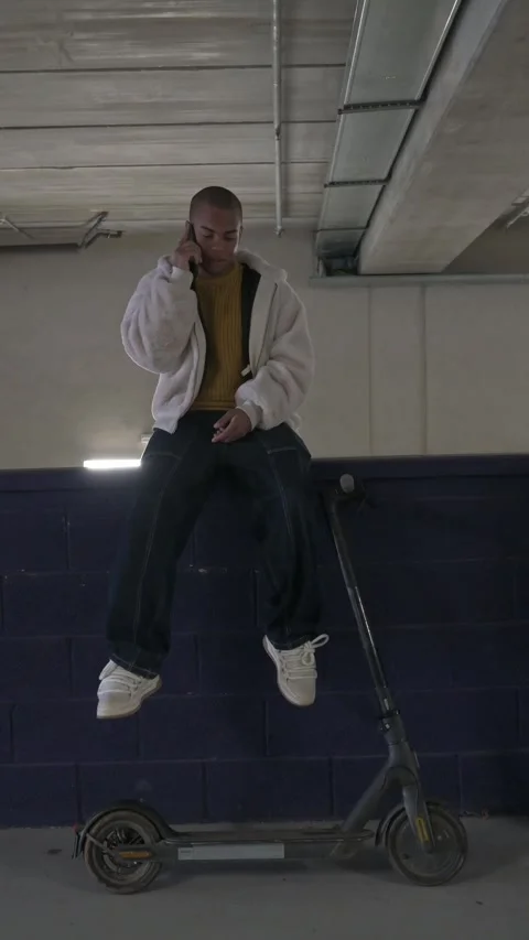 Young man using smart phone over electric scooter Stock Footage 300260309