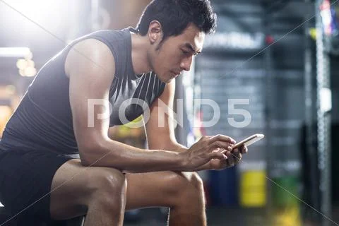 Young man using smart phone in gym Stock Photos