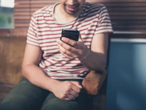 Young man using smart phone at home Photos