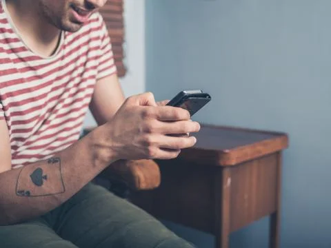 Young man using smart phone at home 库存照片