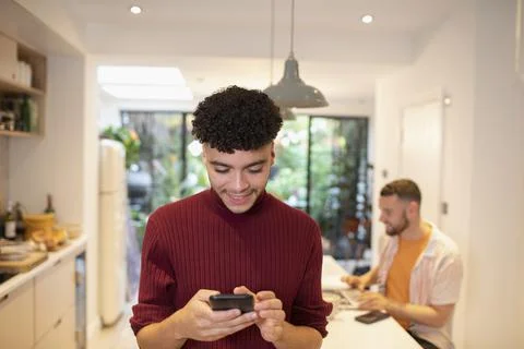 Young man using smart phone in kitchen 스톡 사진