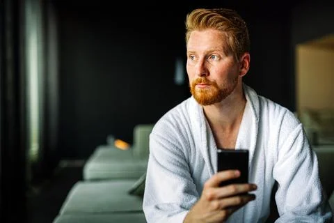 Young man using smart phone for work or to relax and reading news. Social media Stock Photos