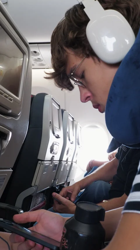 Young Man Using Smartphone on Airplane 스톡 동영상 341835848