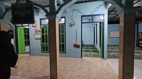 Young Man Using Smartphone And Walking Away In A Local Mosque At Night Stock Footage 339829695