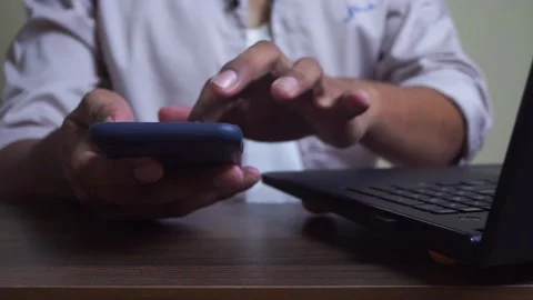 Young man using smartphone and computer for connected business Stock Footage 345582301