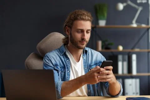 Young man using smartphone and smiling. Happy businessman using mobile phone Stock Photos