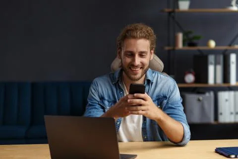 Young man using smartphone and smiling. Happy businessman using mobile phone Stock-Fotos
