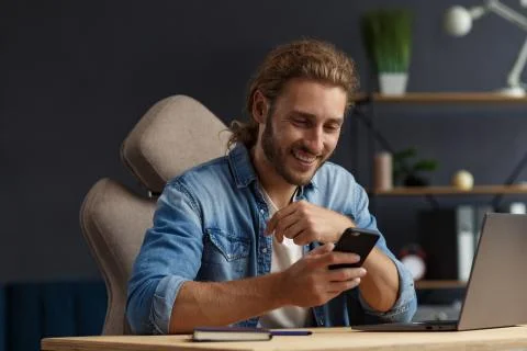 Young man using smartphone and smiling. Happy businessman using mobile phone Stock Photos