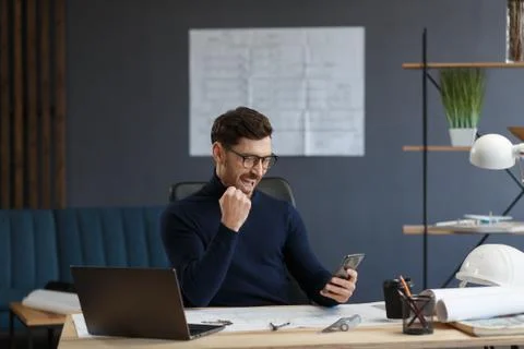 Young man using smartphone and smiling. Happy businessman using mobile phone Foto stock