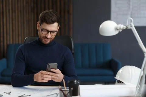 Young man using smartphone and smiling. Happy businessman using mobile phone 스톡 사진