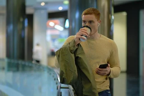 Young man using smartphone and listens to music in bluetooth headphones. lonely Foto stock