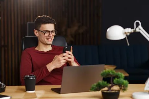Young man using smartphone and smiling. Happy businessman using Stock Photos