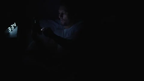 Young man using smartphone in bed at night, selective focus. Insomnia and s.. Stock Footage 289561980