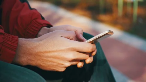 Young Man using a Smartphone on a Bench in the City Park Stock Footage 73888929
