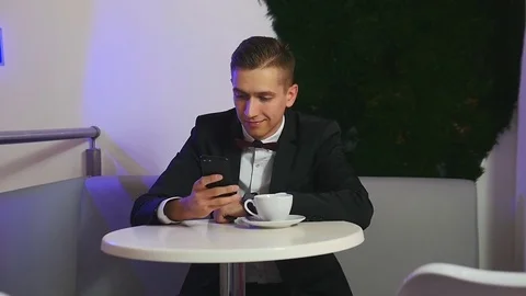 Young man using smartphone in a cafe Stock Footage 75804337
