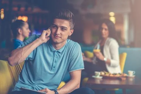 Young Man using a smartphone in the cafe Foto stock