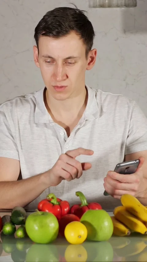 Young man using smartphone calorie counter app for healthy food, tracking Stock Footage 344823362
