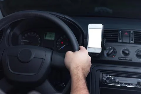 Young man using smartphone in a car. Stock Photos