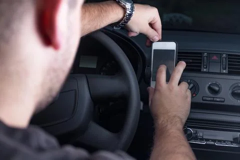 Young man using smartphone in a car. Stock-Fotos