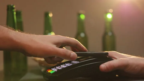 Young man using smartphone cashless wallet NFC technology to pay for order on Stock Footage 194549792