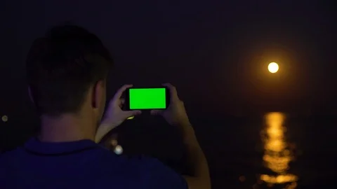 Young man using smartphone with chromakey greenscreen tracking matte on sea Stock Footage 118306630