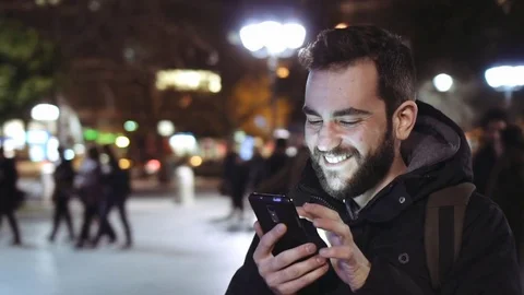 Young man using smartphone at city  landmark at night slomo Vidéo 73160451