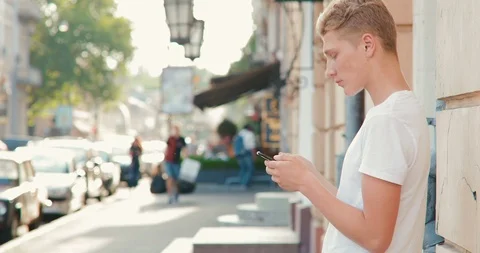 A young man is using a smartphone in the city Stock Footage 91391834