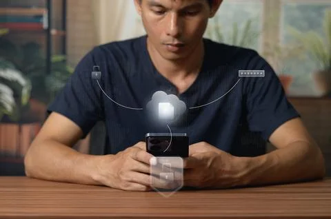 Young Man Using Smartphone with Cloud Computing and Data Transfer Concept Stock Photos