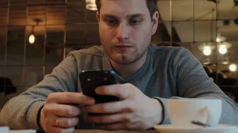 Young man using smartphone in a coffee house Stock Footage 61861261
