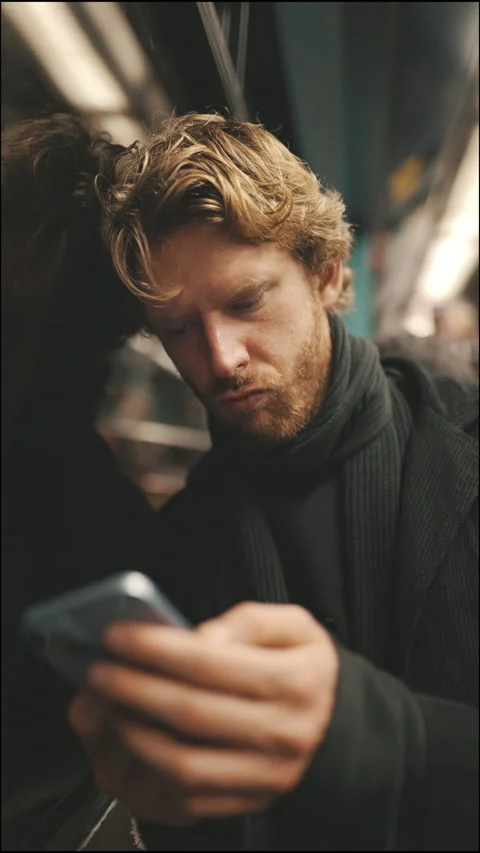 Young man using smartphone commuting on a subway train Stock Footage 328592142