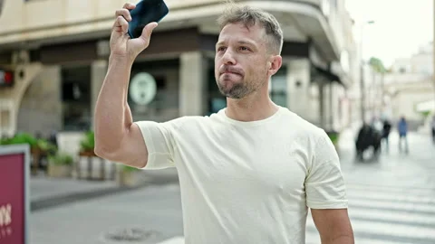 Young man using smartphone doing winner gesture at street Video stock 247378950