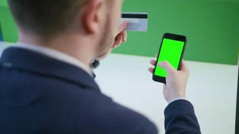 A Young Man Using a Smartphone with a Green Screen Stock Footage 84767621