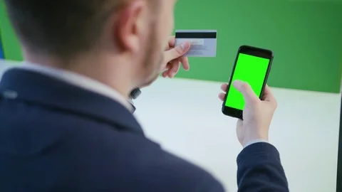A Young Man Using a Smartphone with a Green Screen 스톡 동영상 84767783