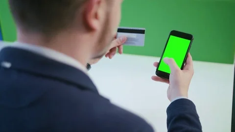 A Young Man Using a Smartphone with a Green Screen Stock Footage 84767955