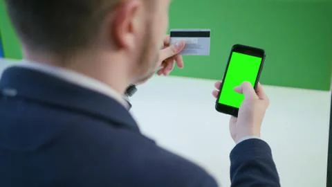 A Young Man Using a Smartphone with a Green Screen Stock Photos
