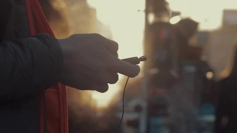 Young man using a smartphone with headset on street. City traffic at background Stock Footage 75178476