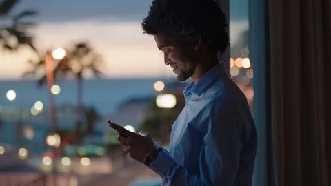 Young man using smartphone in hotel room texting sharing vacation lifestyle on Stock Footage 103485686