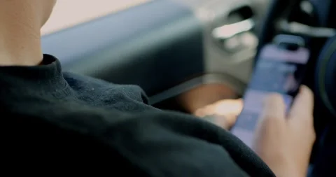 Young man using smartphone inside car, waiting for response. Stock Footage 313951280