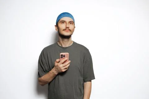 Young man using smartphone isolated on white background. Looking up. Stock Photos